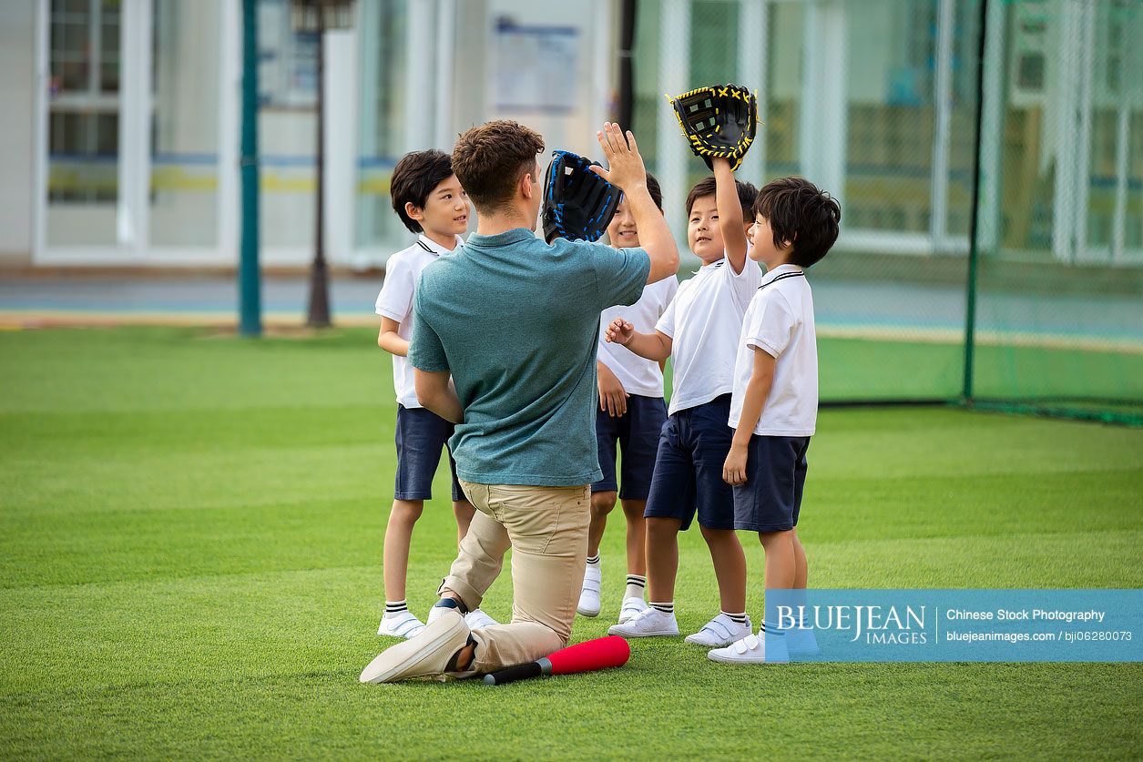 Foreign teacher teaching children basketball