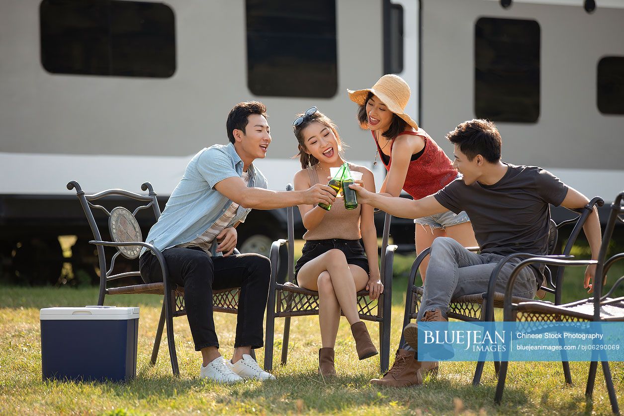 Happy young Chinese friends having a picnic outdoors