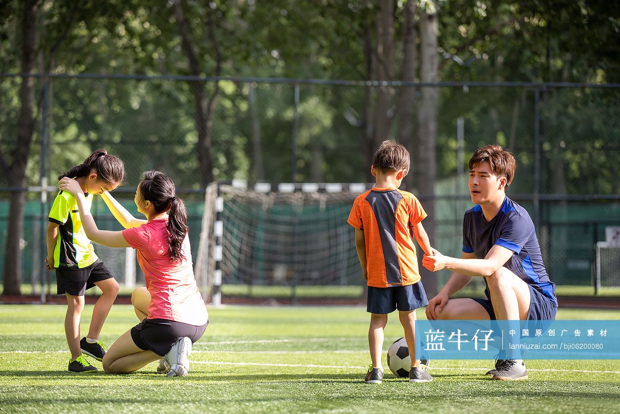 年轻家庭在足球场踢足球