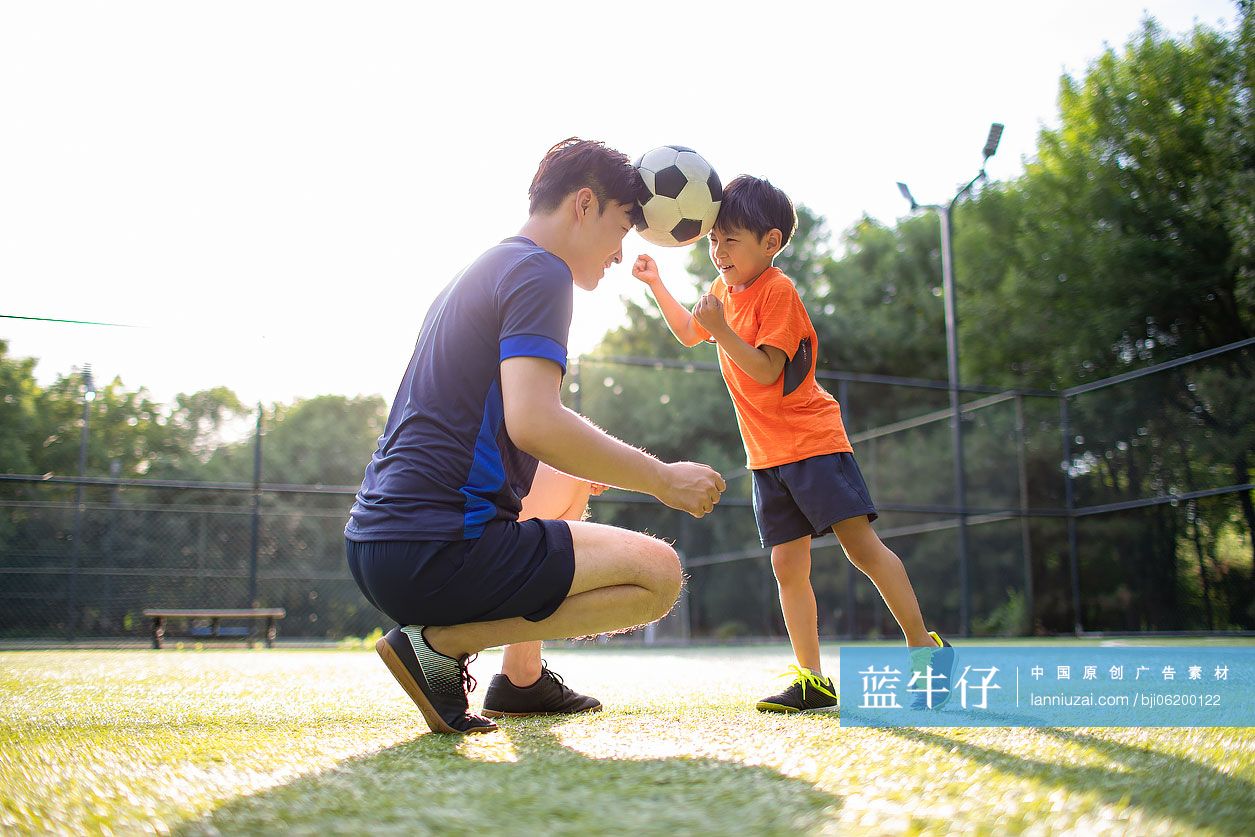 父子俩在足球场玩足球