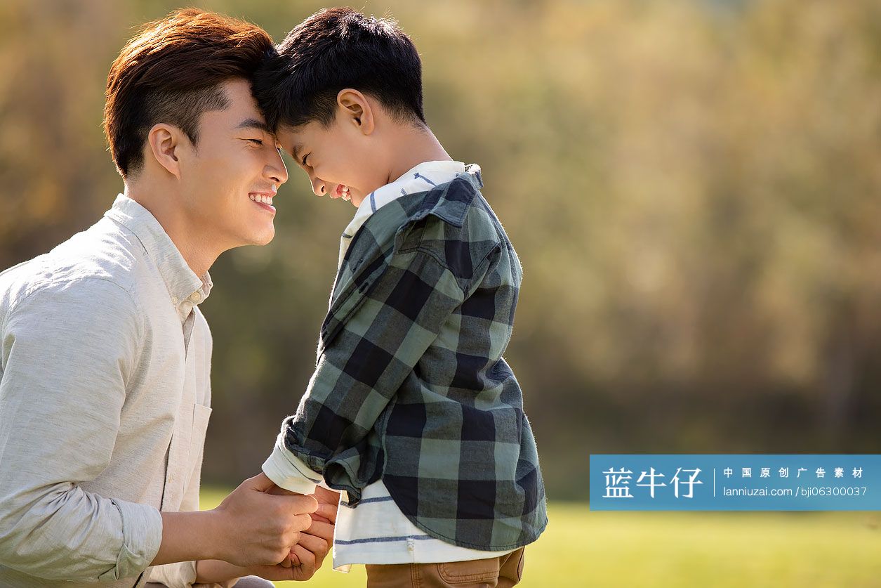 快乐的的父子俩在草地上玩耍