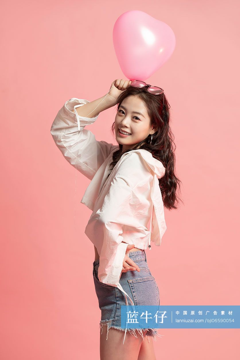 可爱的年轻女孩拿着气球