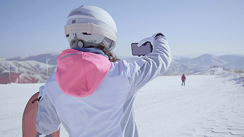 Young Chinese woman using smart phone on the snow,4K