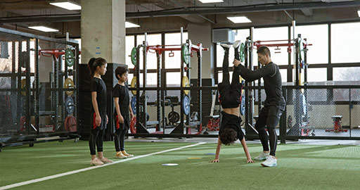 Active Chinese children having exercise class with their coach in gym,4K