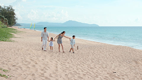 Happy young Chinese family walking on beach,4K