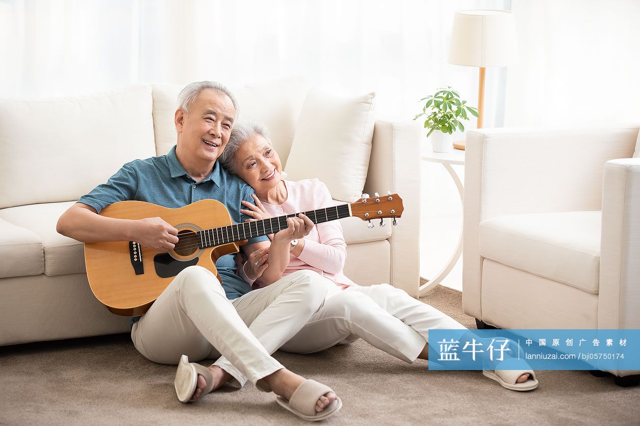 快乐的老年夫妇在客厅弹吉他
