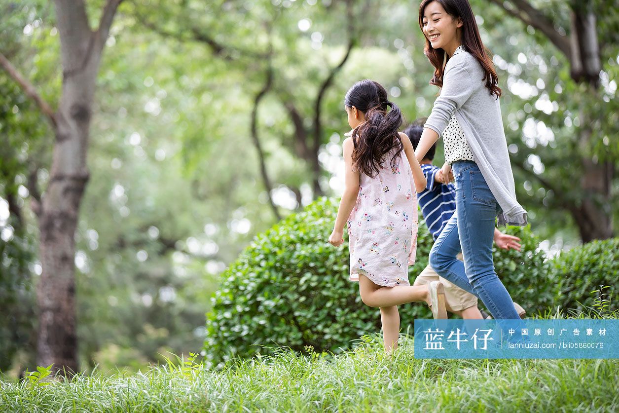 快乐的年轻家庭在草地上奔跑