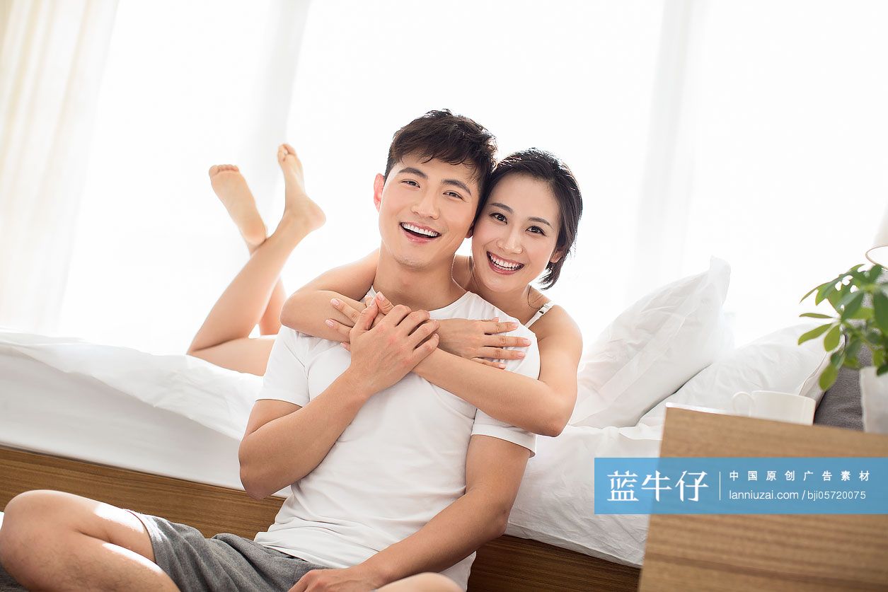 快乐的年轻情侣在卧室共享美好时光-蓝牛仔影像-中国原创广告影像素材