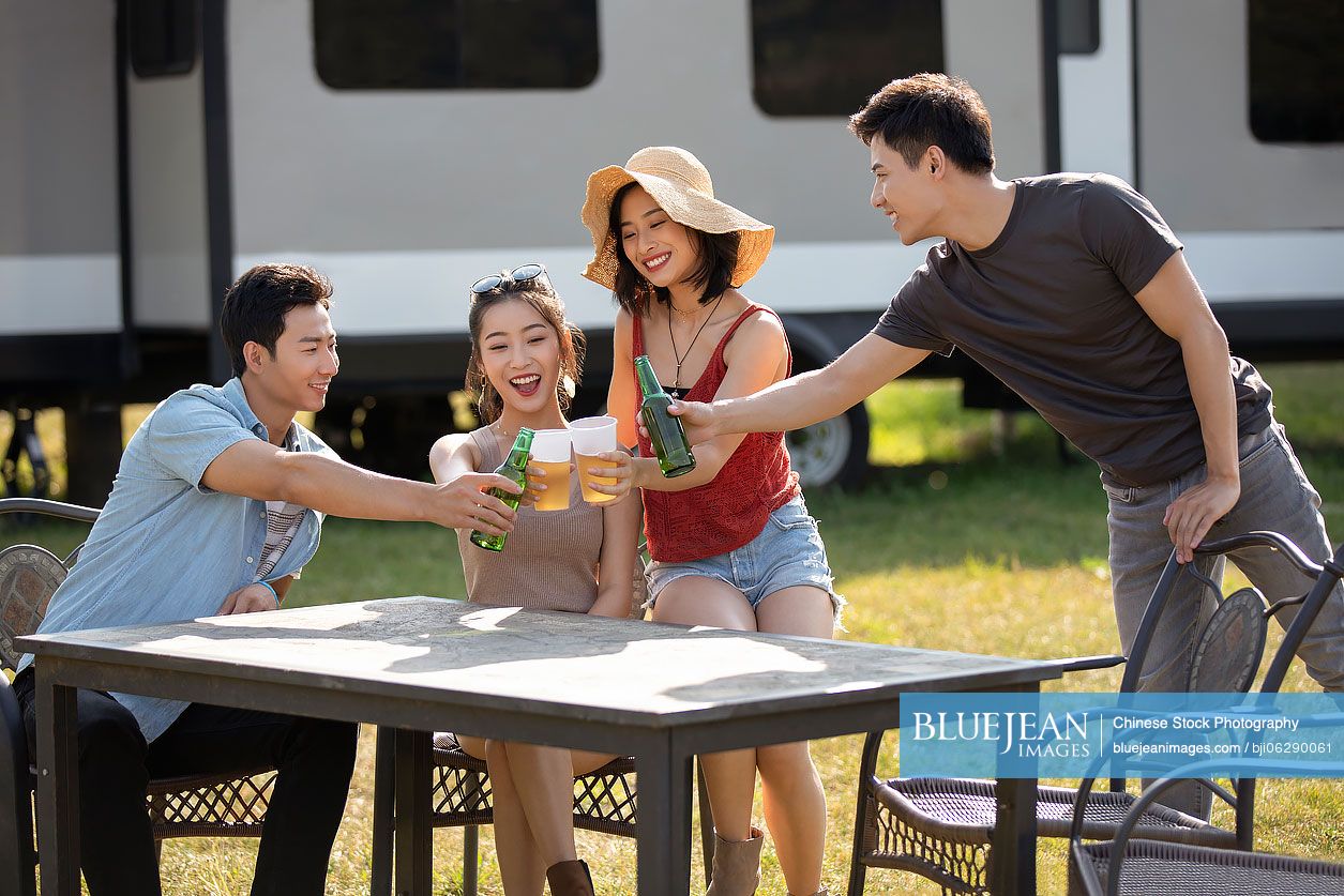 Happy young Chinese friends having a picnic outdoors