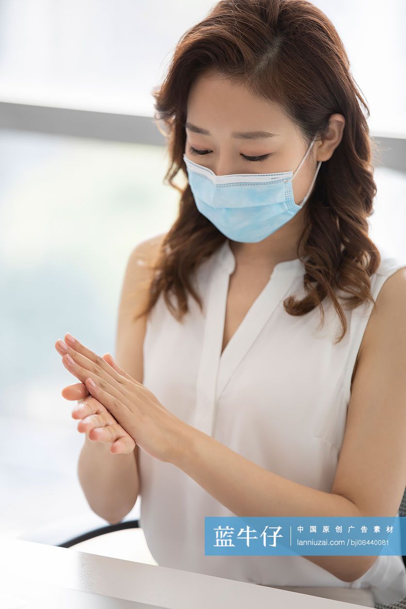 年轻的商务女士在办公室使用免洗洗手液