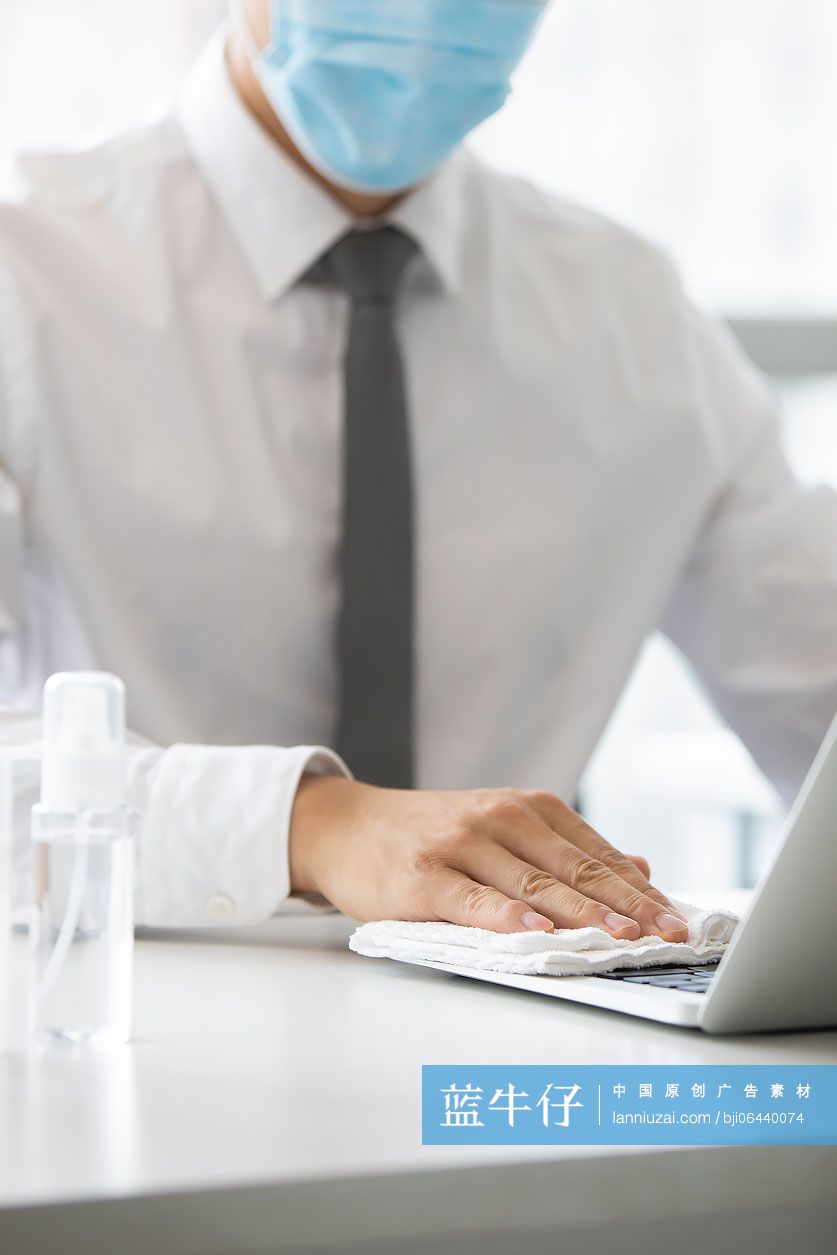 年轻的商务男士在办公室使用消毒液杀菌消毒