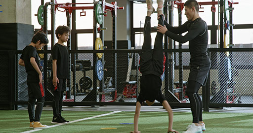 Active Chinese children having exercise class with their coach in gym,4K