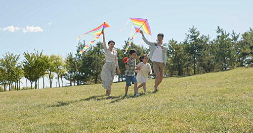 Happy Chinese family running with kites on meadow,4K