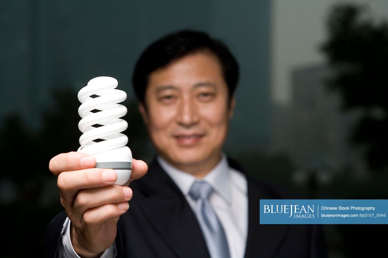 Chinese businessman holding efficient light bulb