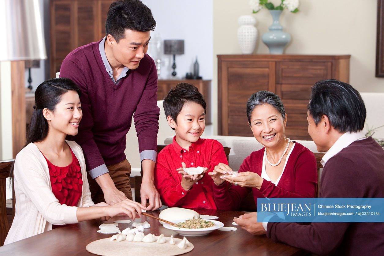 Cheerful family making Chinese dumplings during Chinese New Year