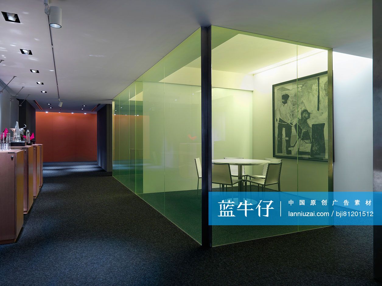 Chairs surrounding circular table in glass cabinet of modern office