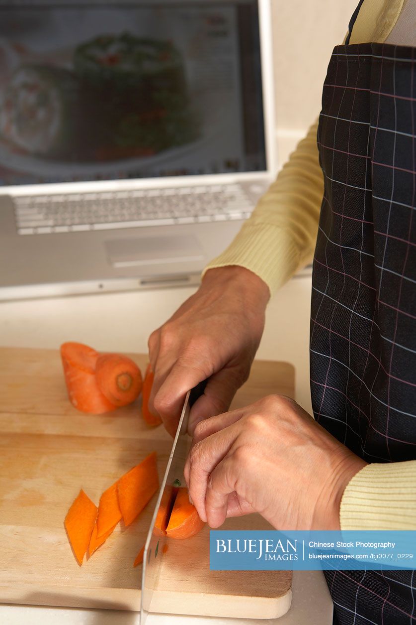 Chinese Woman In The Kitchen Cutting Vegetables