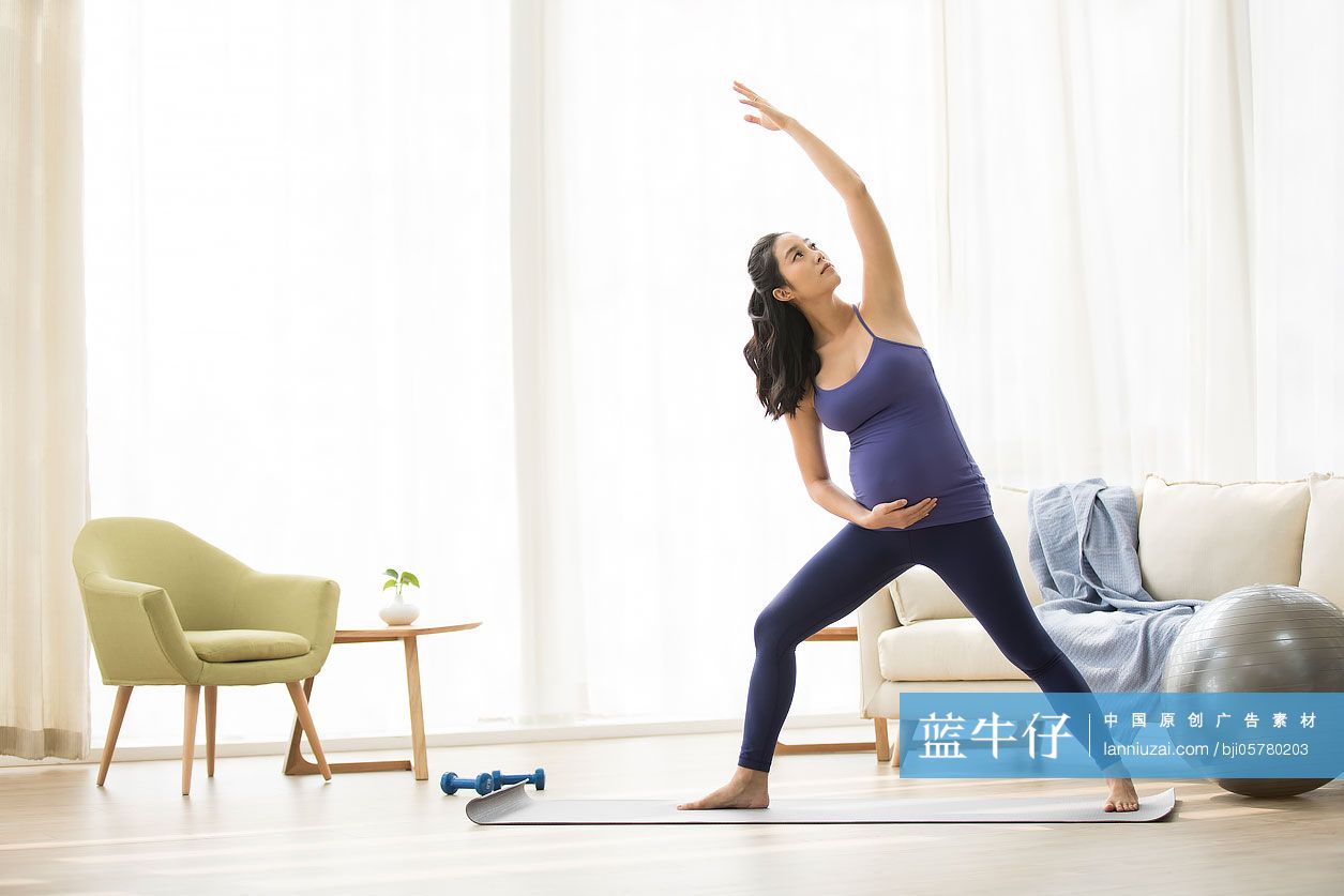 年轻孕妇在家练习瑜伽