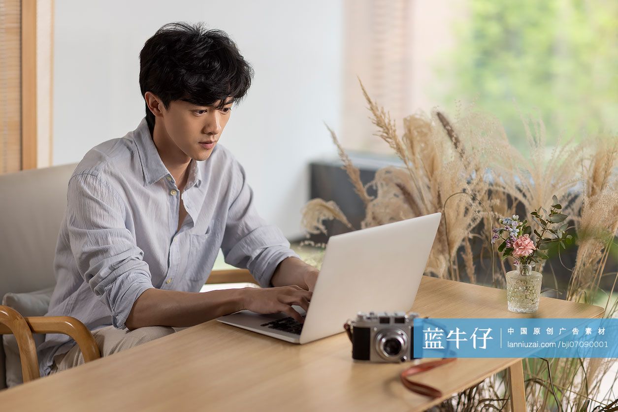 年轻男子在咖啡馆使用笔记本电脑