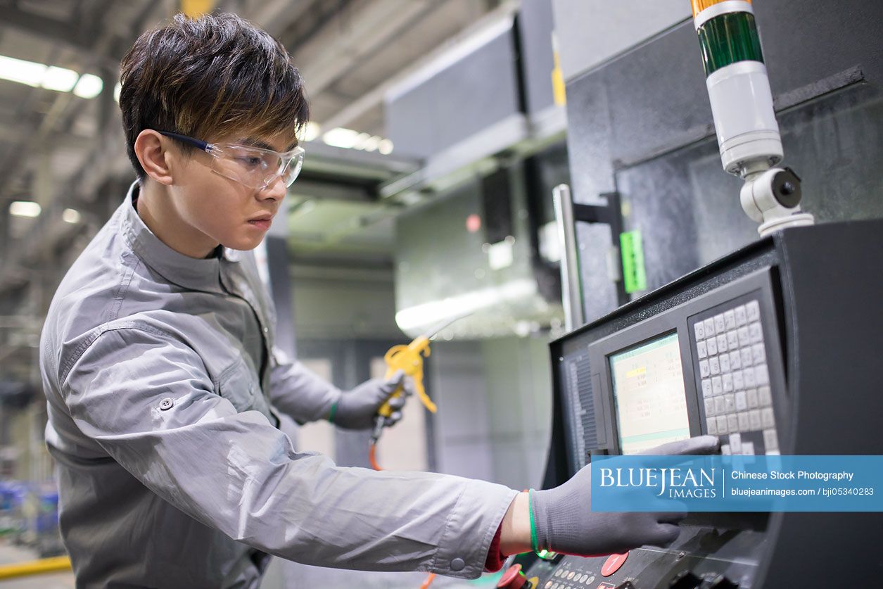 Confident Chinese engineer working in the factory