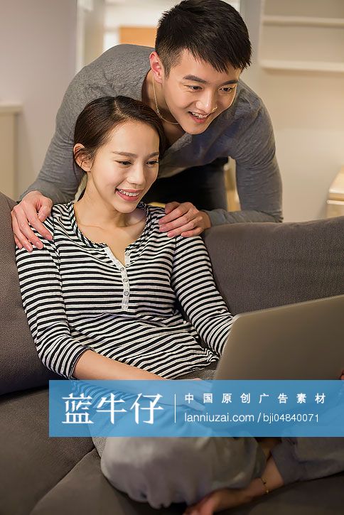 年轻情侣在客厅沙发上使用笔记本电脑-蓝牛仔影像-中国原创广告影像素材