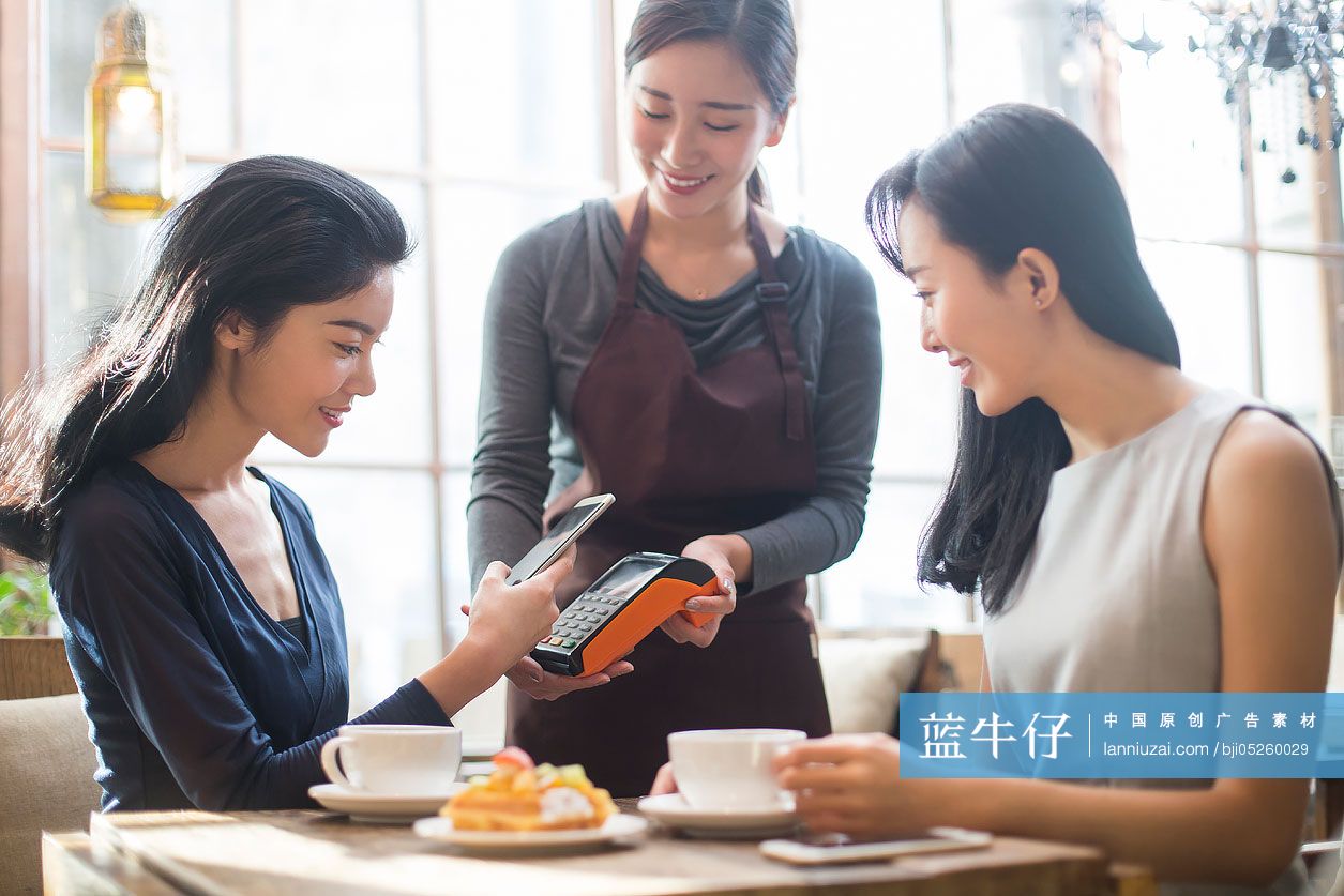 闺蜜俩在咖啡馆用手机结账