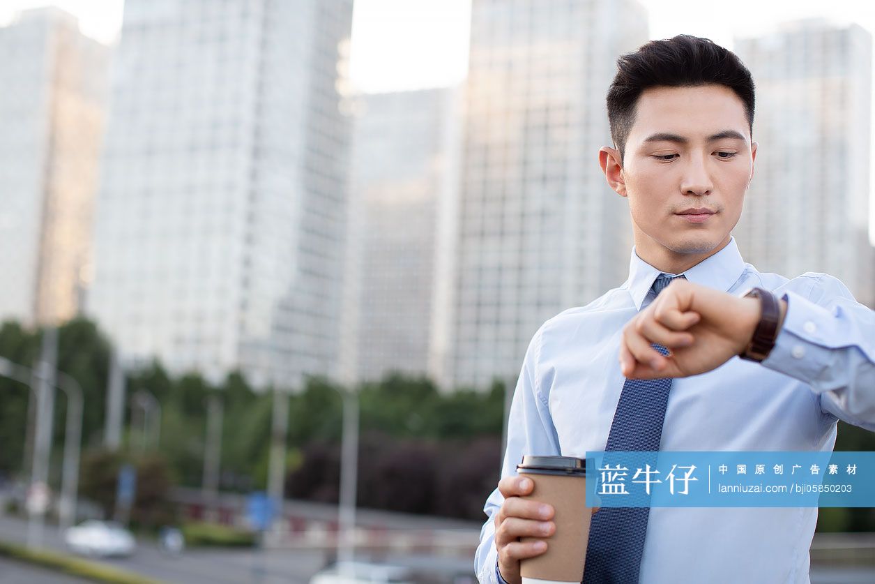 自信的年轻商务男士看时间