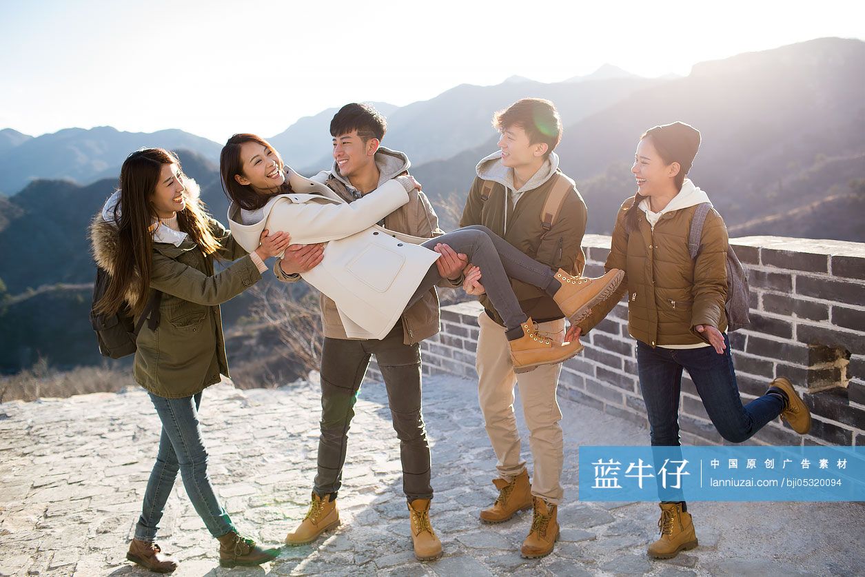 Happy young Chinese friends enjoying winter outing on the Great Wall