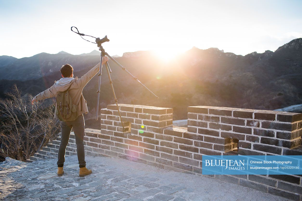 Young Chinese man photographing on the Great Wall