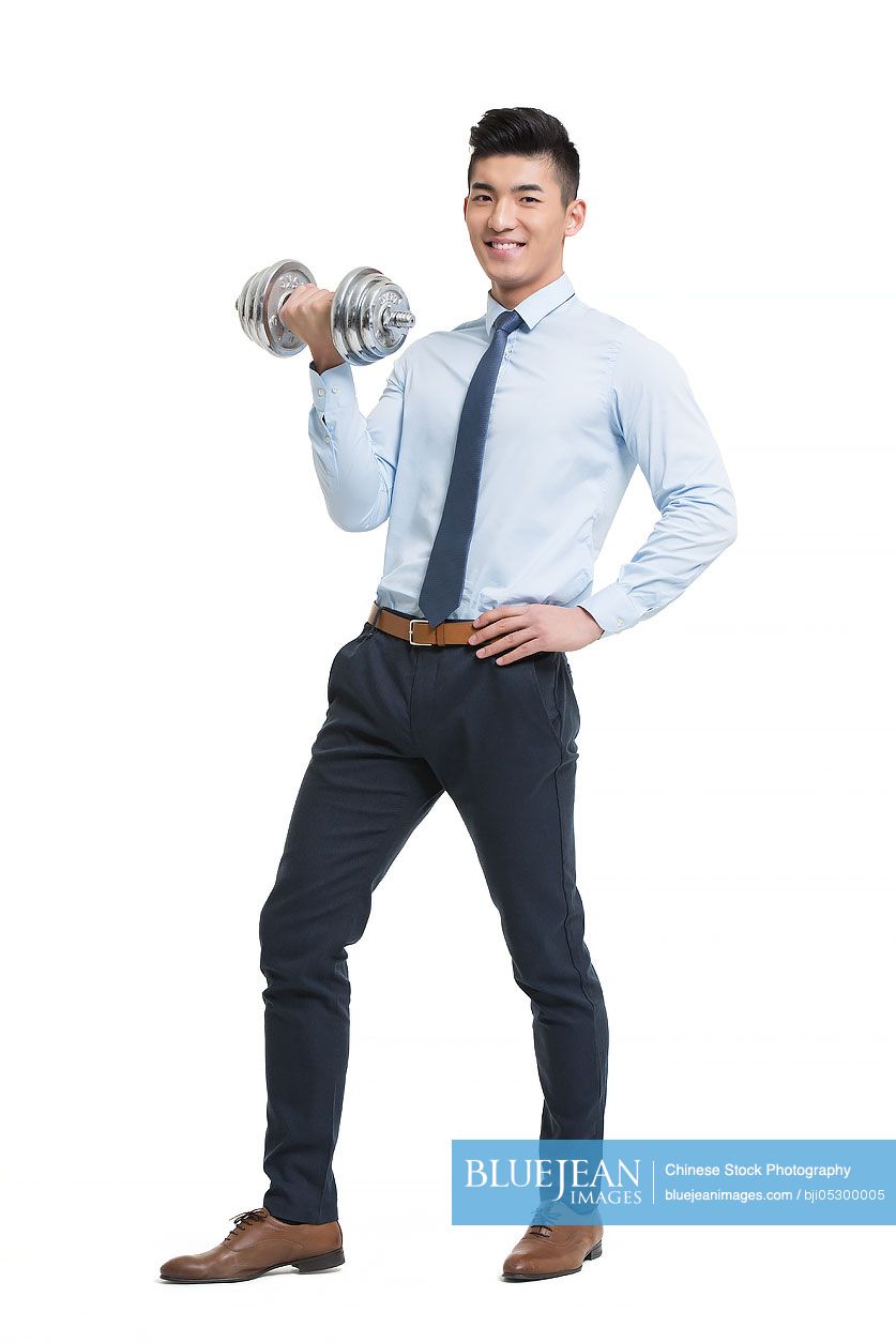 Young Chinese businessman lifting weights