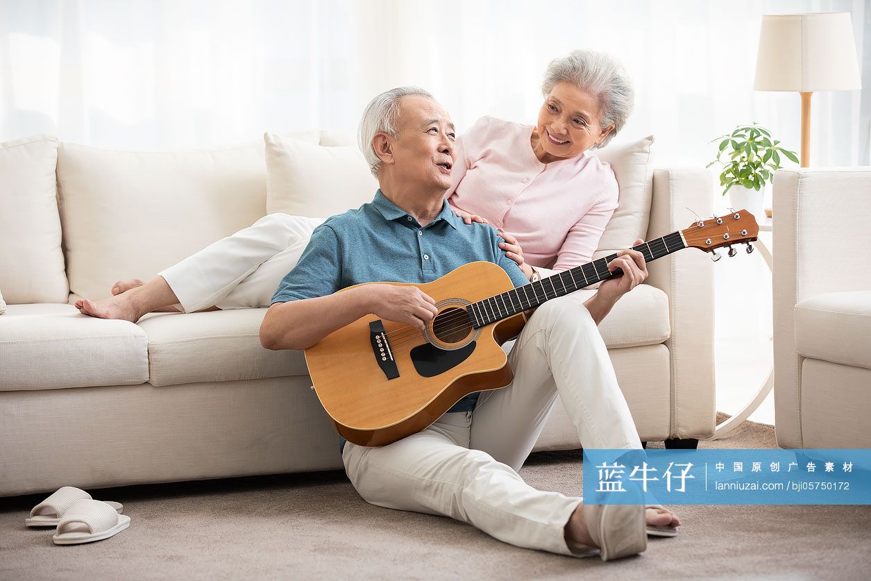 快乐的老年夫妇在客厅弹吉他