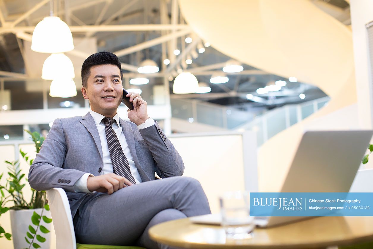 Chinese businessman using smartphone in office