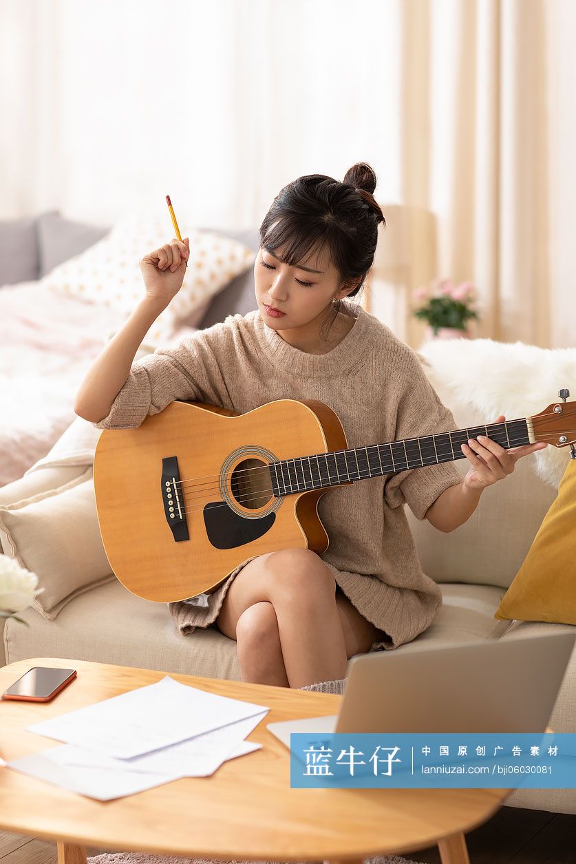 年轻女士在家弹吉他