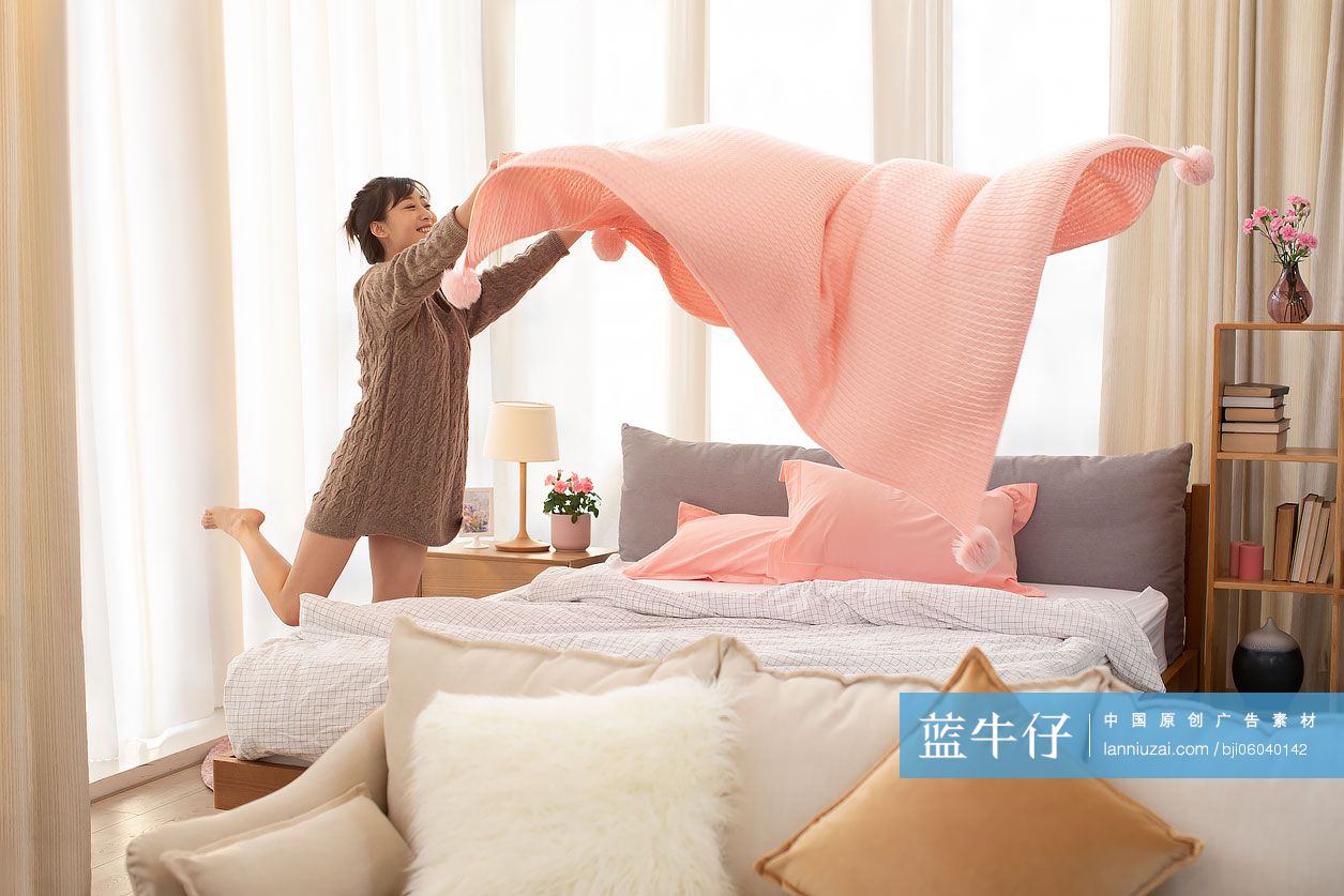 年轻女士整理床铺