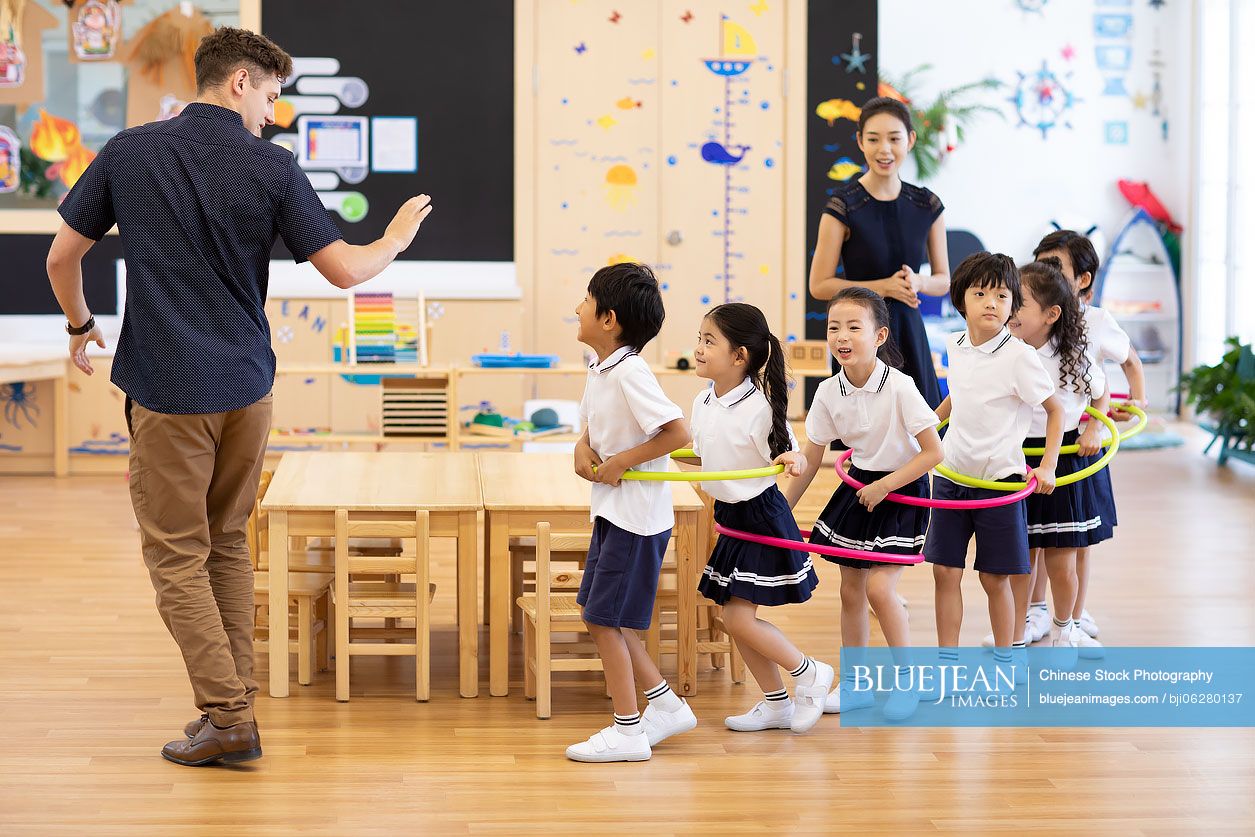 Teachers and children playing games in classroom