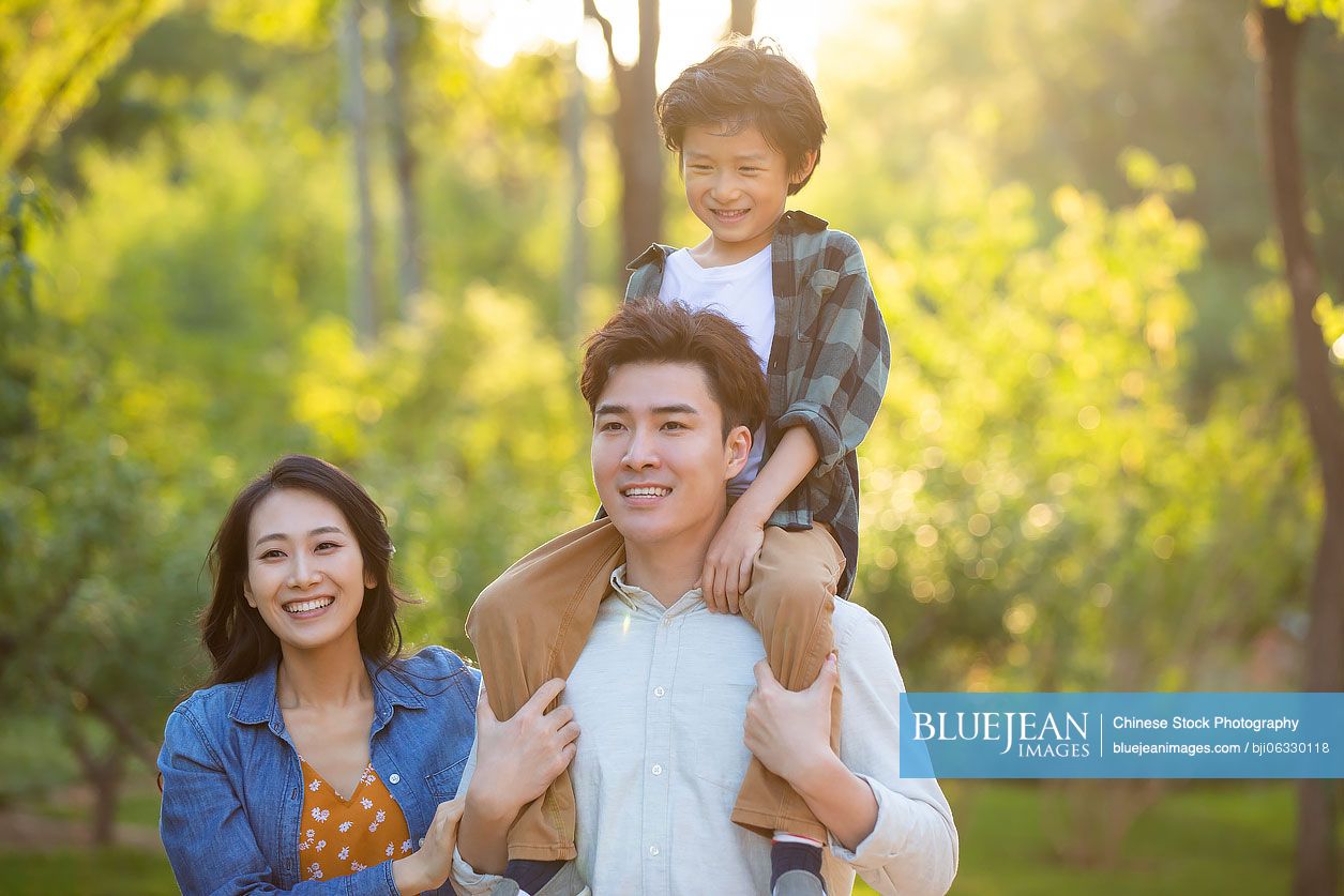 Happy young Chinese family having fun in park
