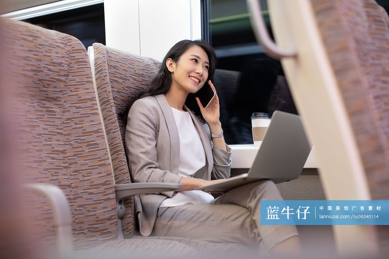 年轻商务女士在高铁上使用手机