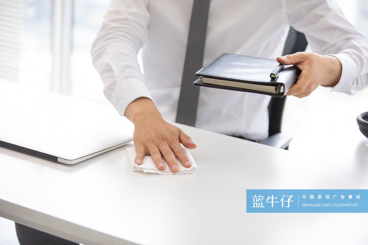 年轻的商务男士在办公室使用消毒液杀菌消毒