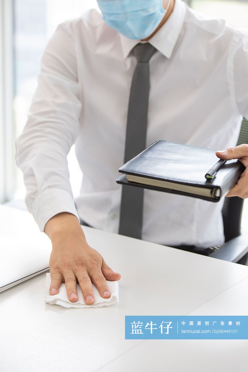 年轻的商务男士在办公室使用消毒液杀菌消毒