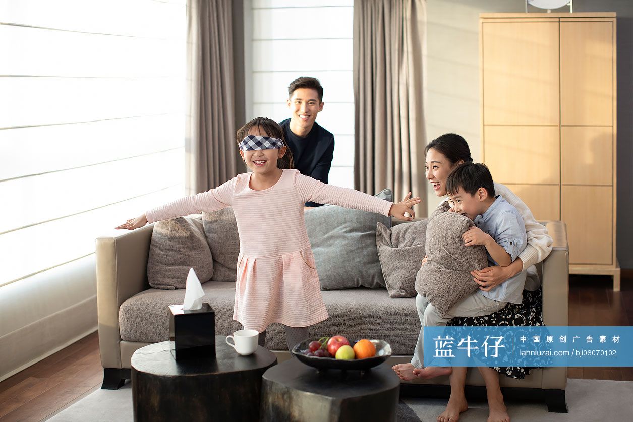 快乐的年轻家庭在客厅玩捉迷藏
