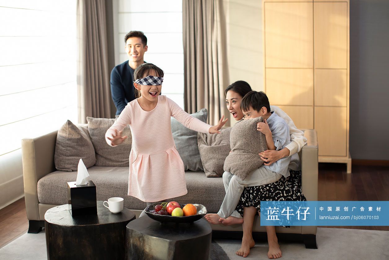 快乐的年轻家庭在客厅玩捉迷藏