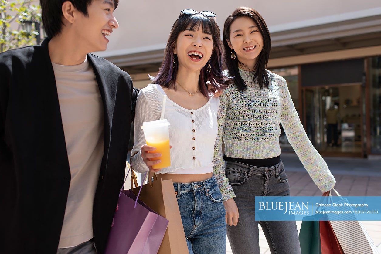 Happy young Chinese friends shopping together