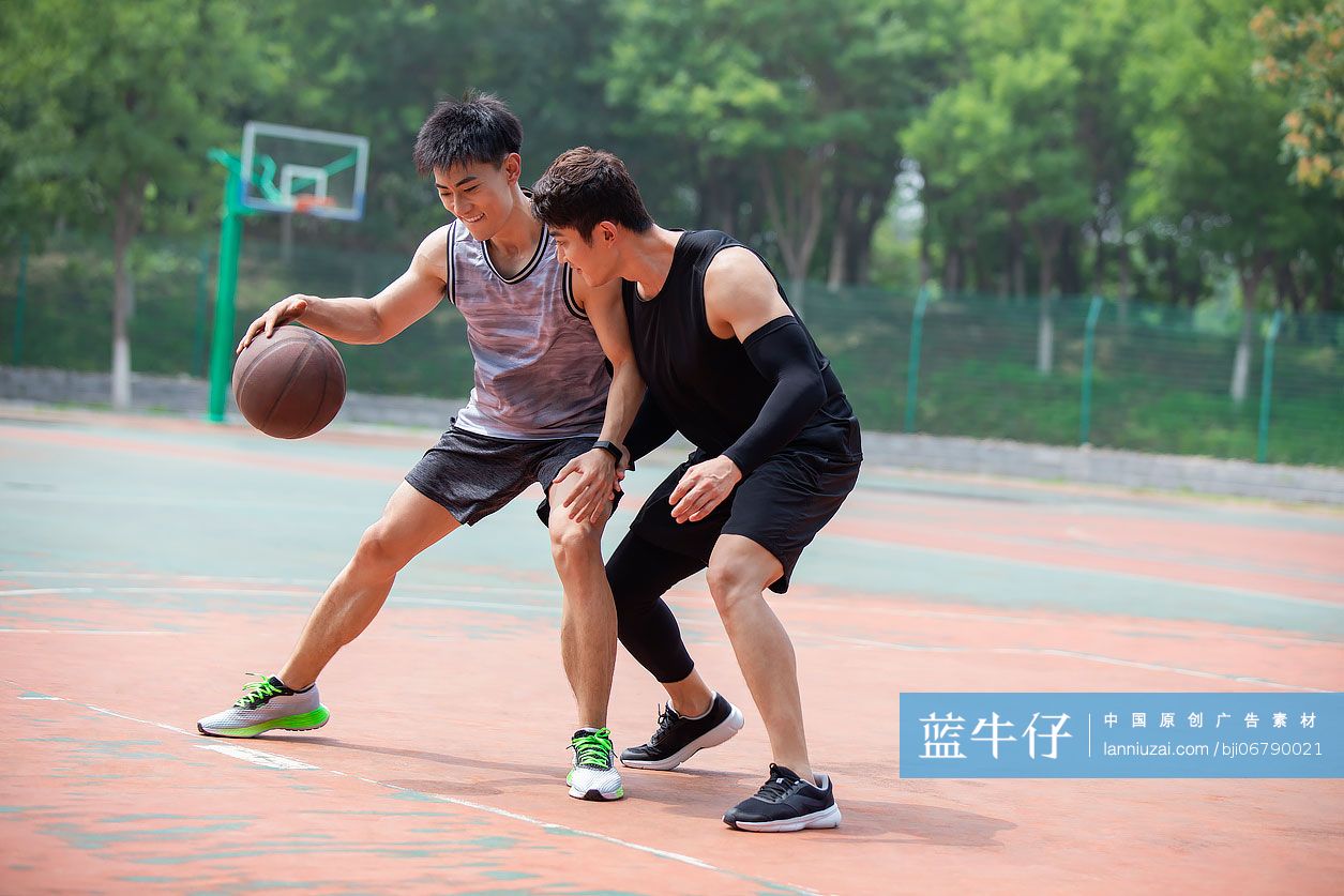 开心的年轻人在篮球场打篮球