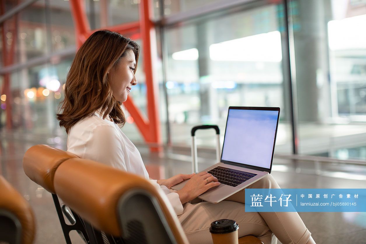 商务女士在机场使用笔记本电脑