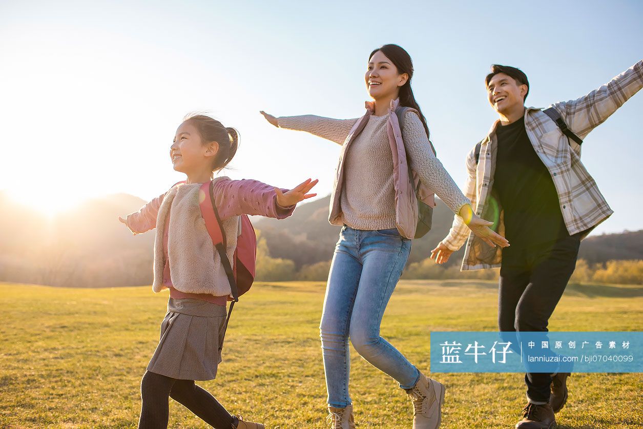 快乐的年轻家庭在草地上玩