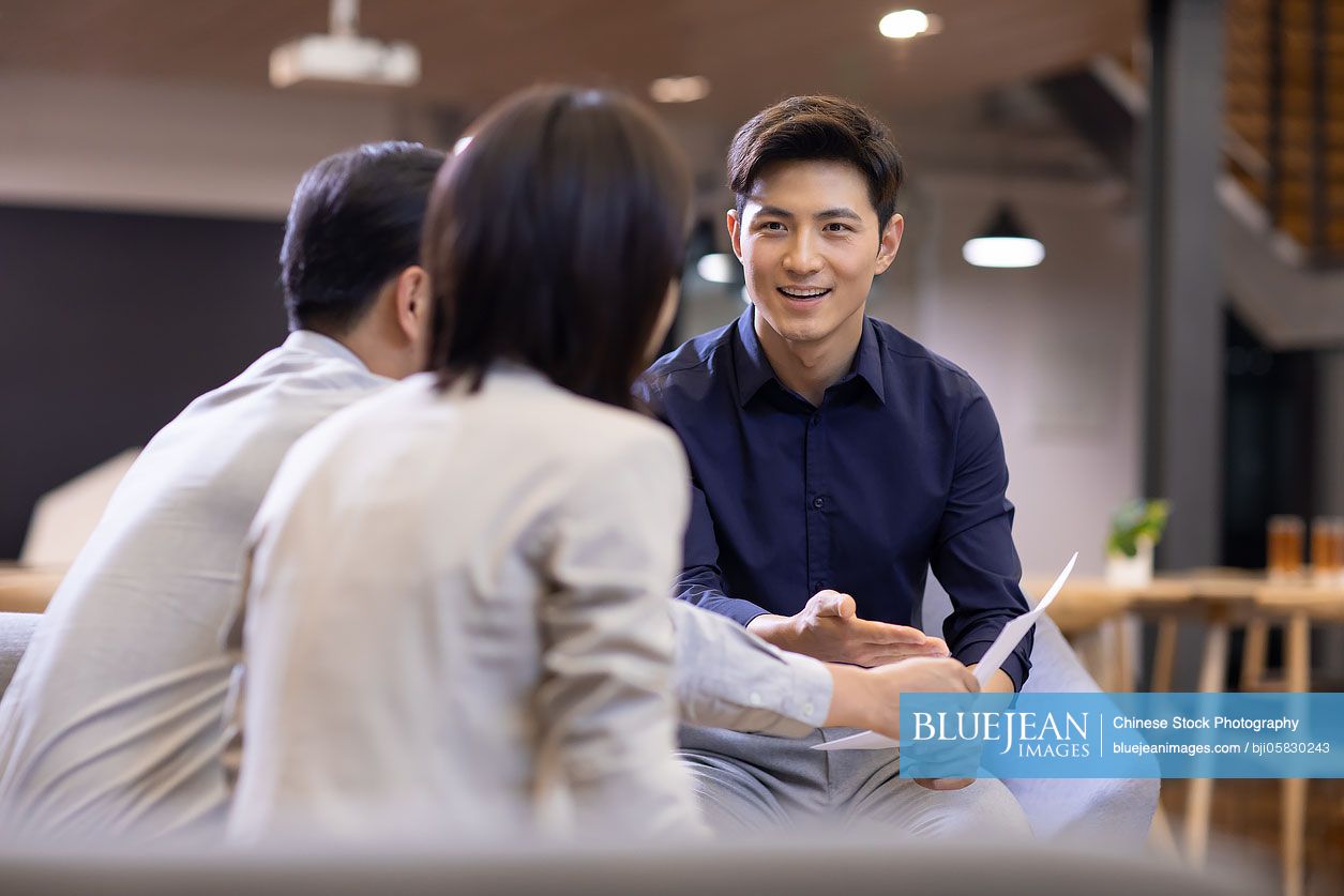 Confident Chinese business people talking in office