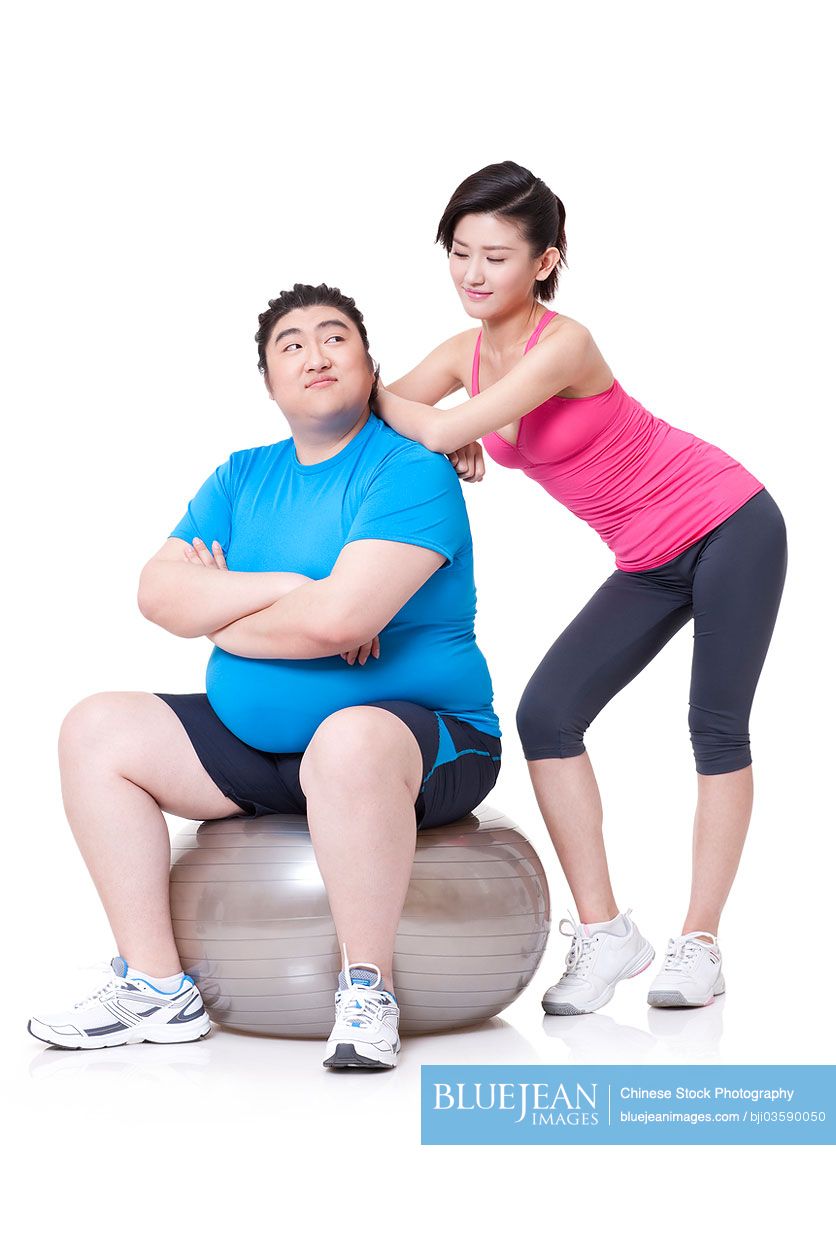 Happy Chubby Chinese man and girlfriend with fitness ball