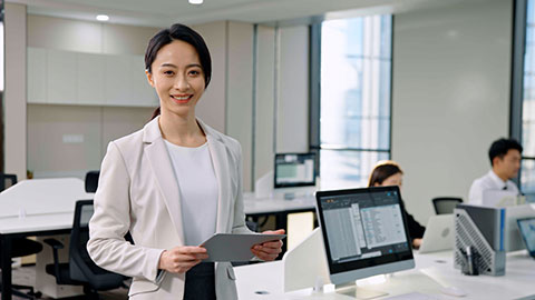 Successful Chinese businesswoman using digital tablet in office