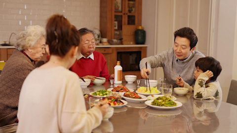 A son gifting his father a fine bottle of spirits to celebrate Chinese New Year