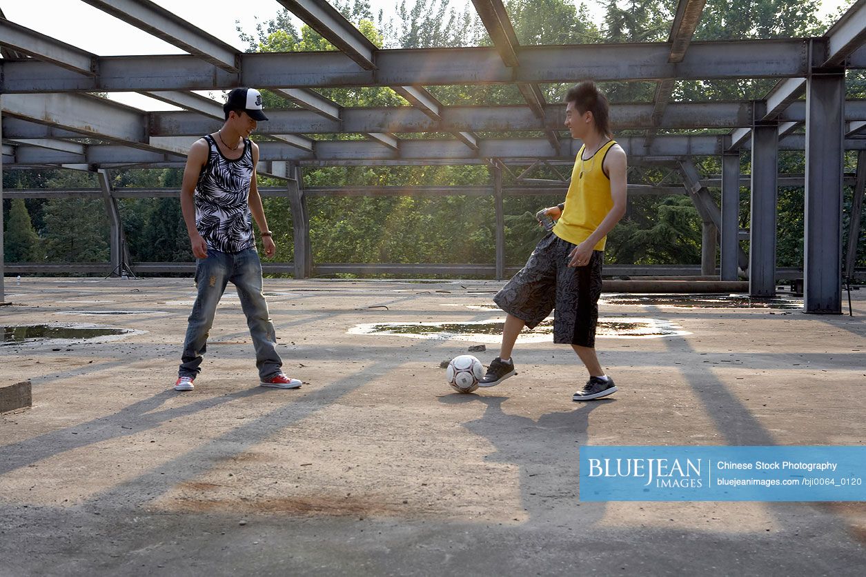 Chinese men kicking soccer bell